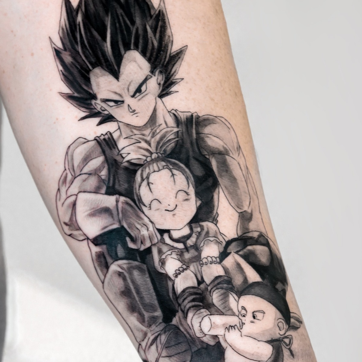 Vegeta con sus hijos, anime en negro y gris tatuado en el antebrazo